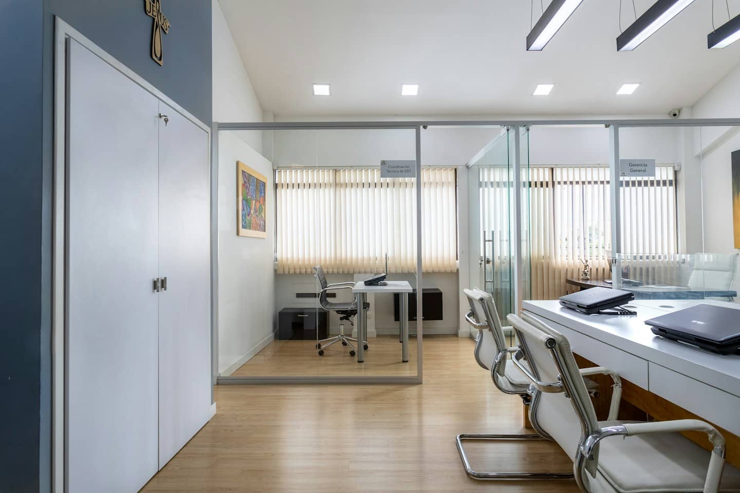 Leeres modernes Büro mit Glaswänden und Besprechungsbereich.